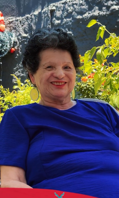 Residente sorrindo em uma área externa
