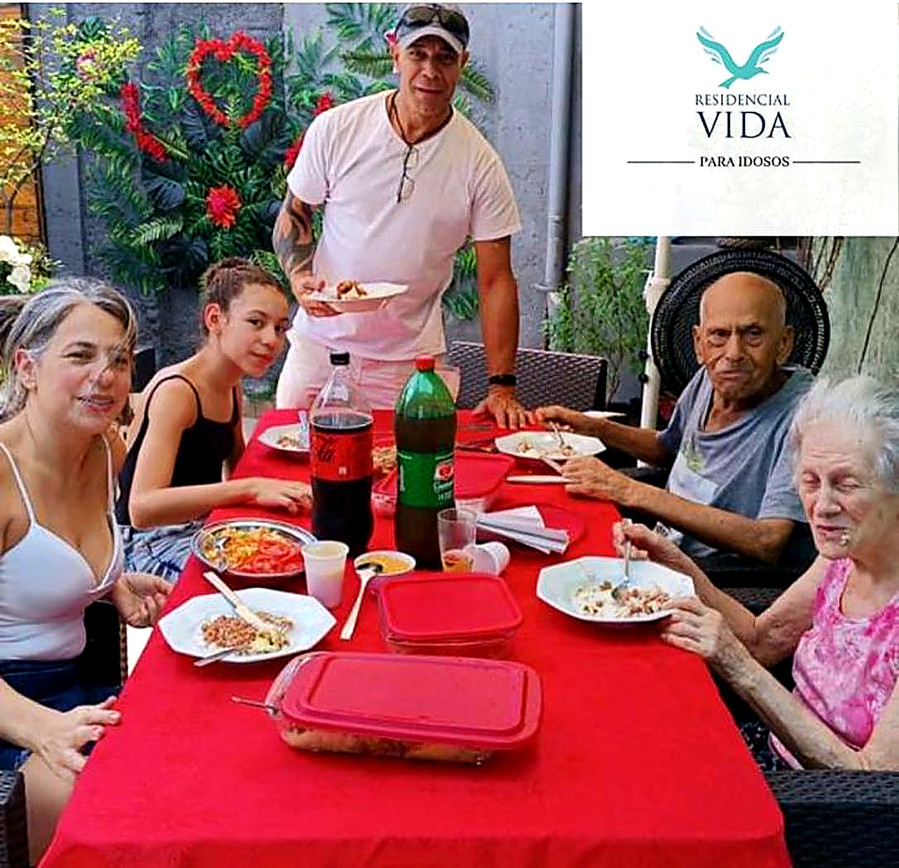 Família e residentes reunidos para uma refeição